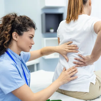 Provider examining a patient's lower back